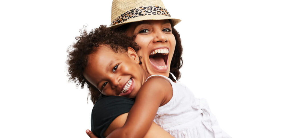Happy mom wearing hat and hugging young daughter